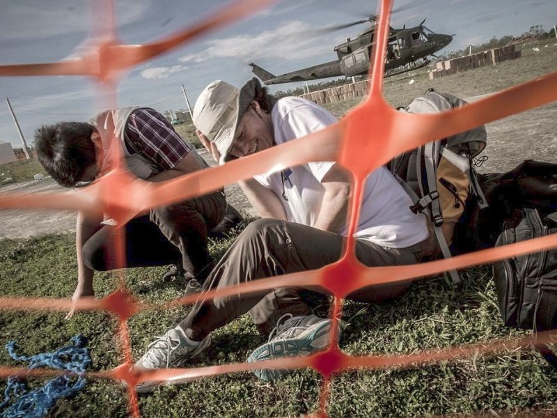 Katastrophenhelfer von ACF, einer Partnerorganisation der Kindernothilfe beladen einen Hubschrauber der Kanadischen Armee mit Nahrungspaketen. Die Notfallnahrung versorgt die Menschen für 14 Tage. Die Kanadische Armee fliegt die Hilfsgüter un unzugängliche Gebiete in den Bergen.  Die Katastrophenhelferin Lucile von ACF führt Angelika Böhling durch die Unglücksgebiete 28.11.2013 auf der Insel Panay - Phillippinen    Bild: Jakob Studnar