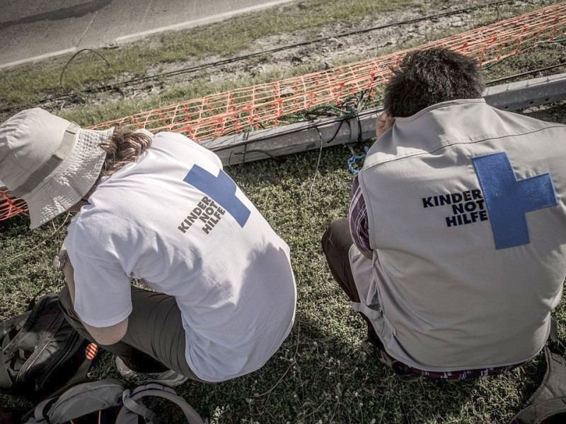 Katastrophenhelfer von ACF, einer Partnerorganisation der Kindernothilfe beladen einen Hubschrauber der Kanadischen Armee mit Nahrungspaketen. Die Notfallnahrung versorgt die Menschen für 14 Tage. Die Kanadische Armee fliegt die Hilfsgüter un unzugängliche Gebiete in den Bergen.  Die Katastrophenhelferin Lucile von ACF führt Angelika Böhling durch die Unglücksgebiete 28.11.2013 auf der Insel Panay - Phillippinen    Bild: Jakob Studnar