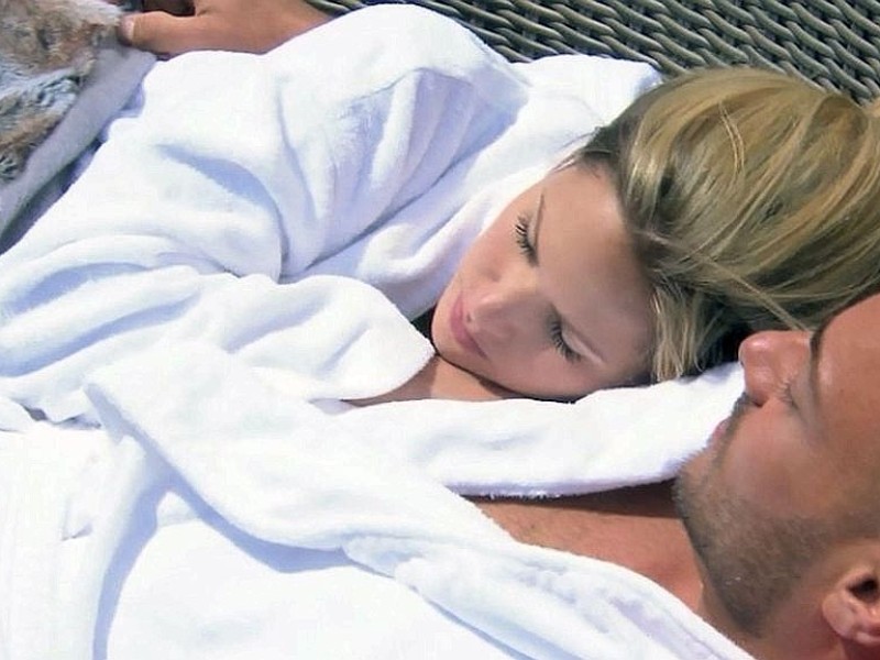 Nach einem Bad im Pool kuscheln Angelina und Christian in Bademänteln auf der Terasse der Bachelor-Villa.