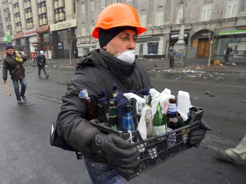 Ein Mann trägt Molotowcocktails in Richtung Maidan...