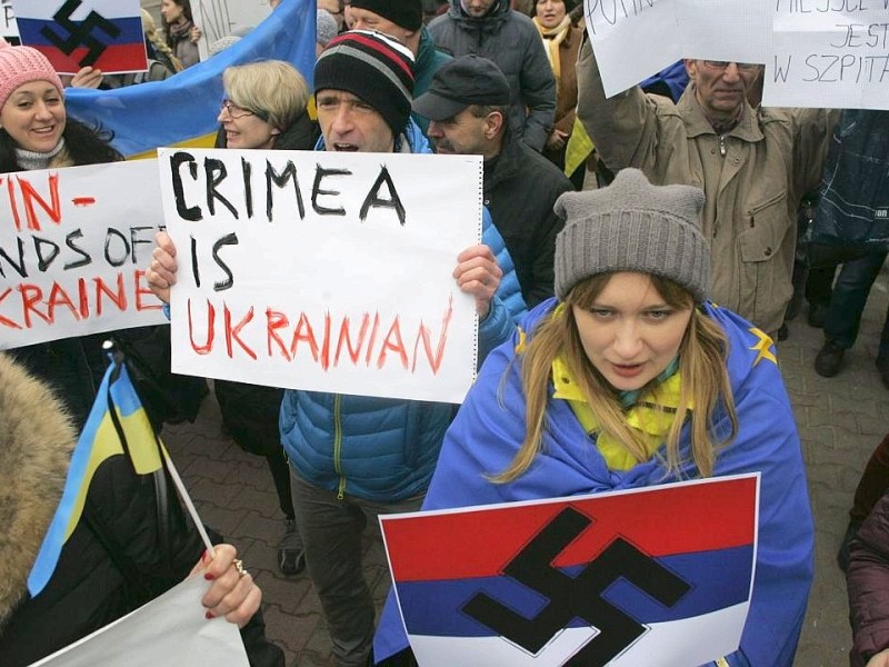 ... Warschau. Polnische Demonstranten halten Schilder hoch mit der Aufschrift Die Krim ist ukrainisch.