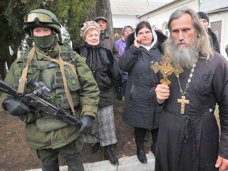 Mit kirchlichem Beistand blockieren Soldaten den Eingang eines ukrainischen Grenzpostens.