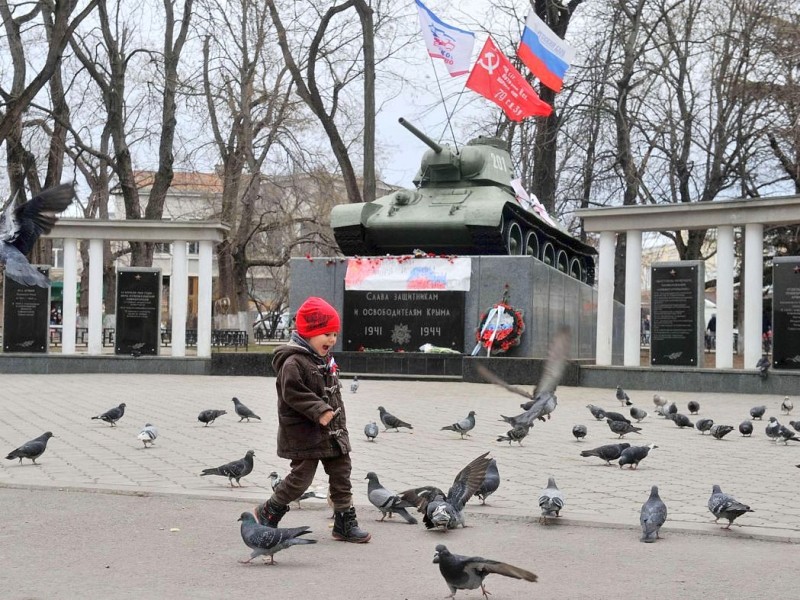 Selbst die ganz Kleinen zeigen Flagge: In Simferopol trägt ein Junge eine Schleife in den Farben der russischen Flagge. Im Hintergrund sieht man einen ausgestellten T-34-Panzer.