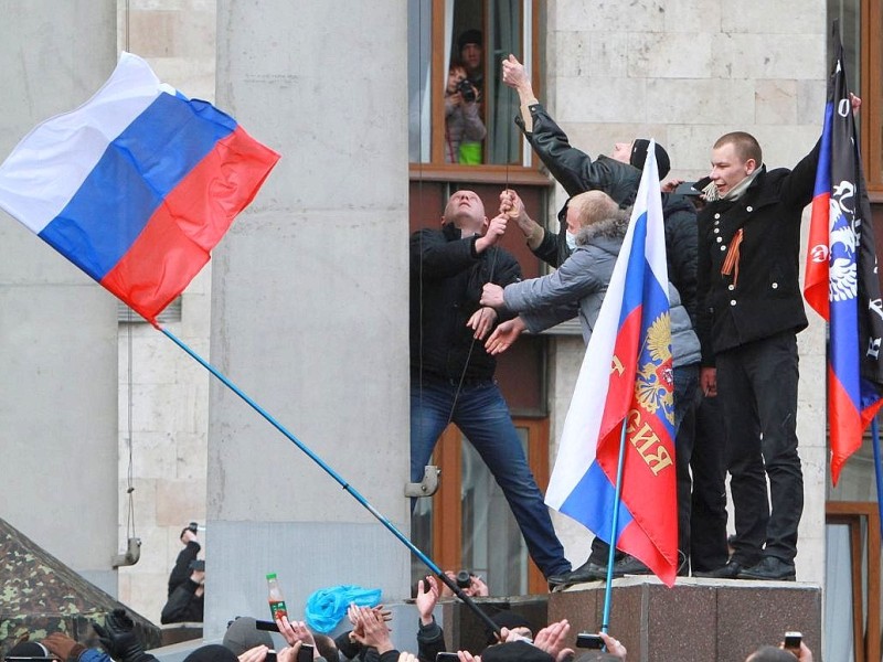In Donezk stellen Demonstranten eine russische Flagge auf.