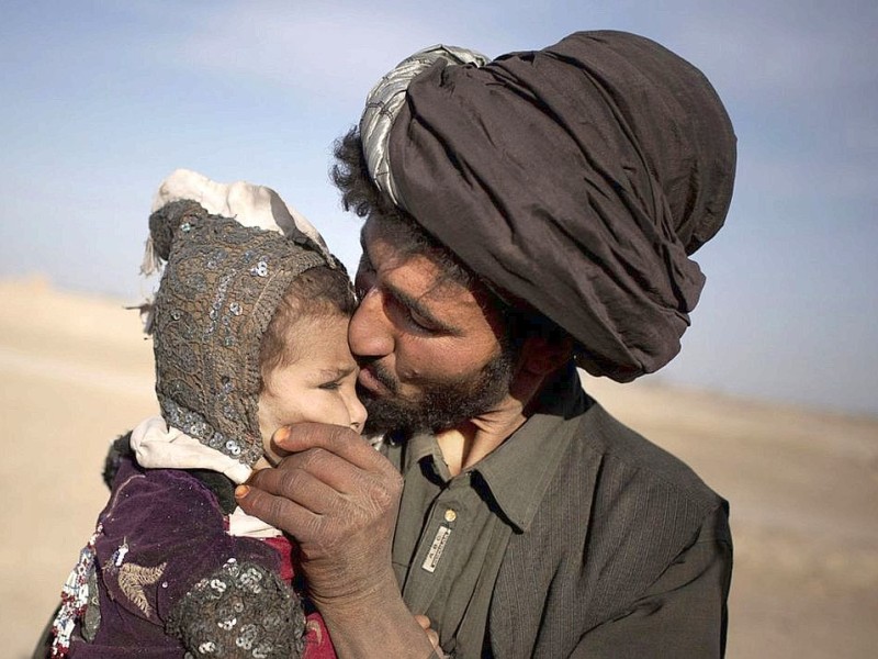 Ein afghanischer Nomade küsst seine kleine Tochter in der Provinz Helmand.
