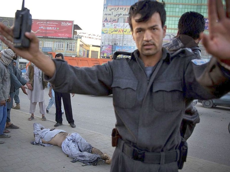 Ein Polizist hält die Menschen zurück, nachdem eine Bombe unter einem Auto im Zentrum der afghanischen Hauptstadt Kabul explodiert ist.