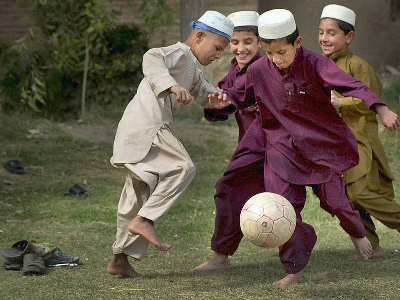 Afghanische Jungen spielen Fußball.