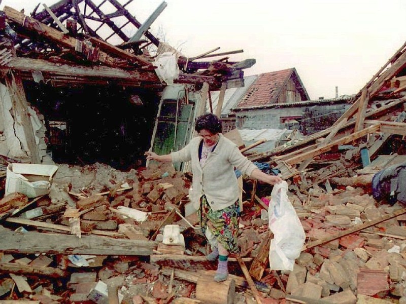 Die bosnische Muslima Ziba Suba sucht 1995 in den Trümmern ihres bei einem serbischen Angriff zerstörten Wohnhauses in Sarajevo nach den letzten Habseligkeiten.