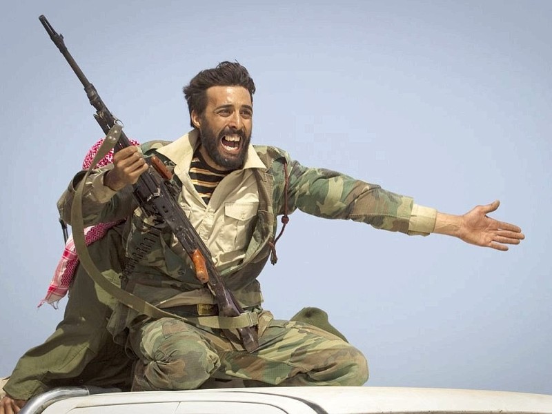 Ein libyscher Rebell warnt Menschen vor dem Beschuss durch Gaddafis Truppen in der Nähe von Bin Jawaad.