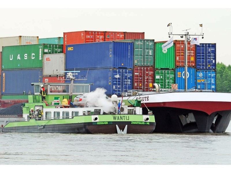 Das Foto zeigt die  Löscharbeiten der Feuerwehr an dem mit Kohle beladenen niederländischen Schiff Wantij, das auf dem Rhein bei Rees Mehr einen Motorbrand hatte und dadurch manoverierunfähig geworden ist. Zur Stabilisierung während des Löschvorgangs wurde das Schiff an das Containerschiff Salute angedockt.