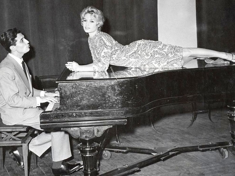 Der französische Sänger, Komponist und Schauspieler Gilbert Becaud mit Brigitte Bardot (1960).