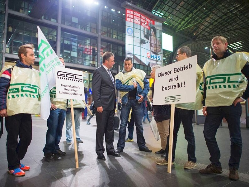 Claus Weselsky (M), Chef der Gewerkschaft Deutscher Lokomotivführer (GDL), unterhält sich mit streikenden Lokführern und Zugbegleitern am Hauptbahnhof in Berlin.
