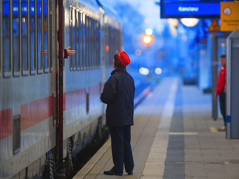 Eine Bahnmitarbeiterin spricht kurz nach dem Streik der Lokführer in Rostock mit einem Reisenden in einem Fernzug.