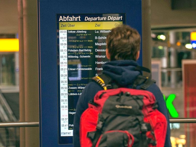 Ein Reisender steht in Berlin am Hauptbahnhof vor einer Informationstafel.