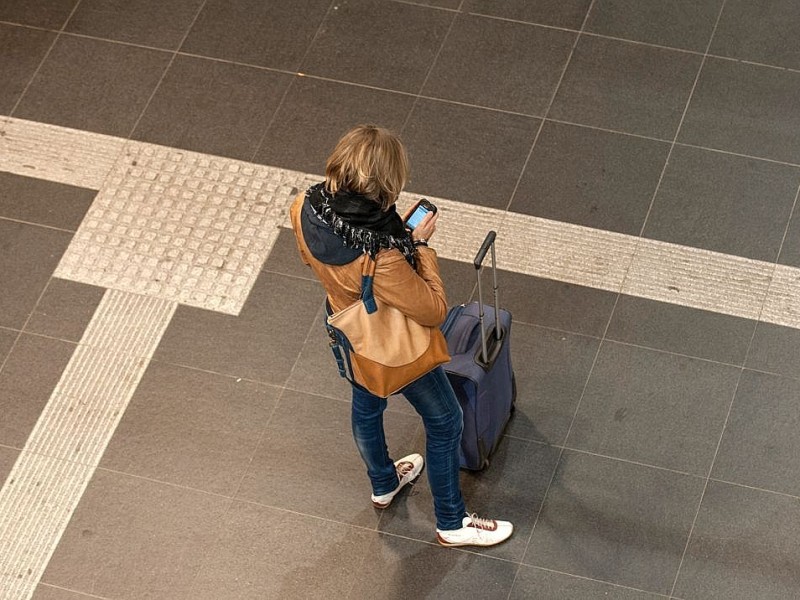 Eine Reisende schaut auf ihr Handy.