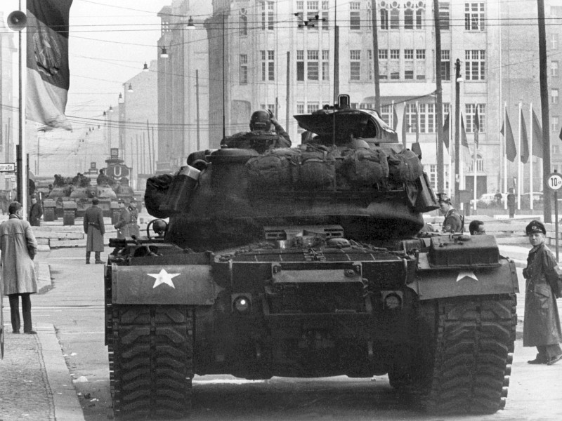 Die Friedrichstraße am Checkpoint Charlie in Berlin im Oktober 1961. Von der Hochzeit des Kalten Krieges ist ...