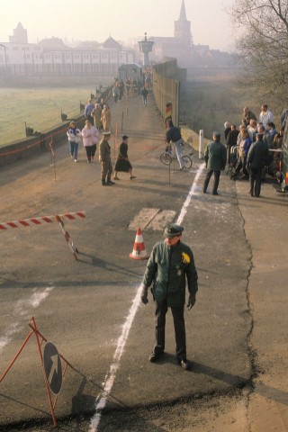 Menschen gehen im Dezember 1989 an der Werrabrücke von Vacha (Thüringen) nach Philippsthal (Hessen). Die Mauer ist an dieser Stelle abgerissen, dafür markiert ein weißer Strich die Grenze. ...