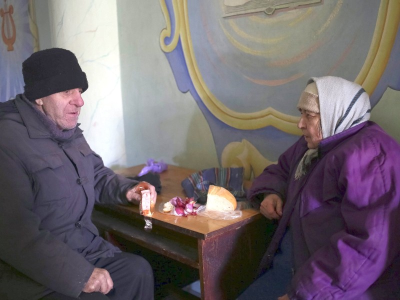 Die beiden älteren Flüchtlinge essen zusammen.