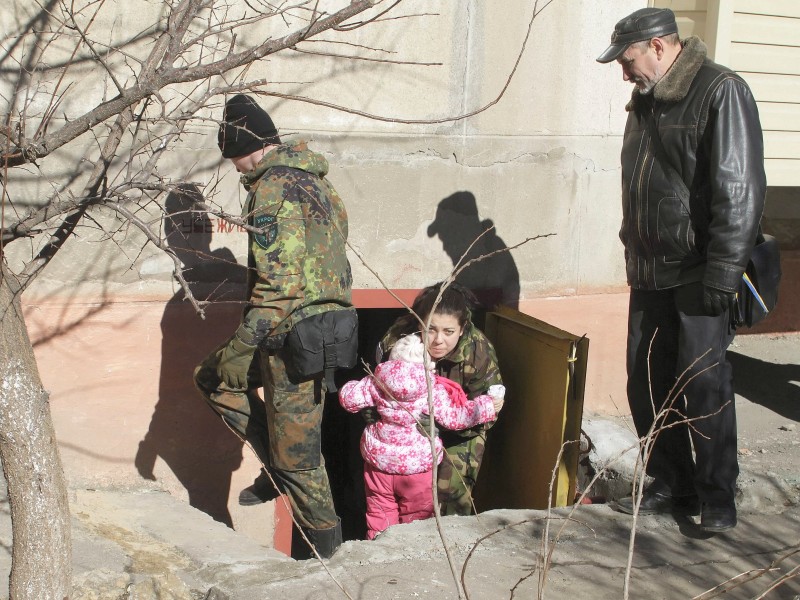 Bei einer Übung helfen Soldaten den Menschen, aus dem Luftschutzbunker in Mariupol zu kommen.