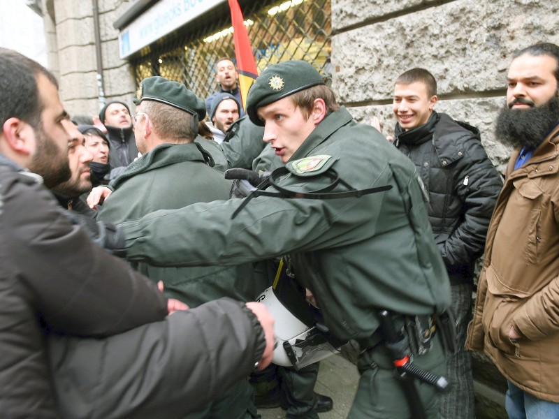 Ein Polizist versucht die Teilnehmer einer Demonstration von Salafisten (r) vor Gegendemonstranten zu schützen.