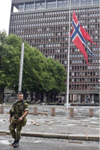 Ein Soldat hisst die norwegische Flagge vor dem Regierungshauptsitz auf Halbmast. Auch dort ...