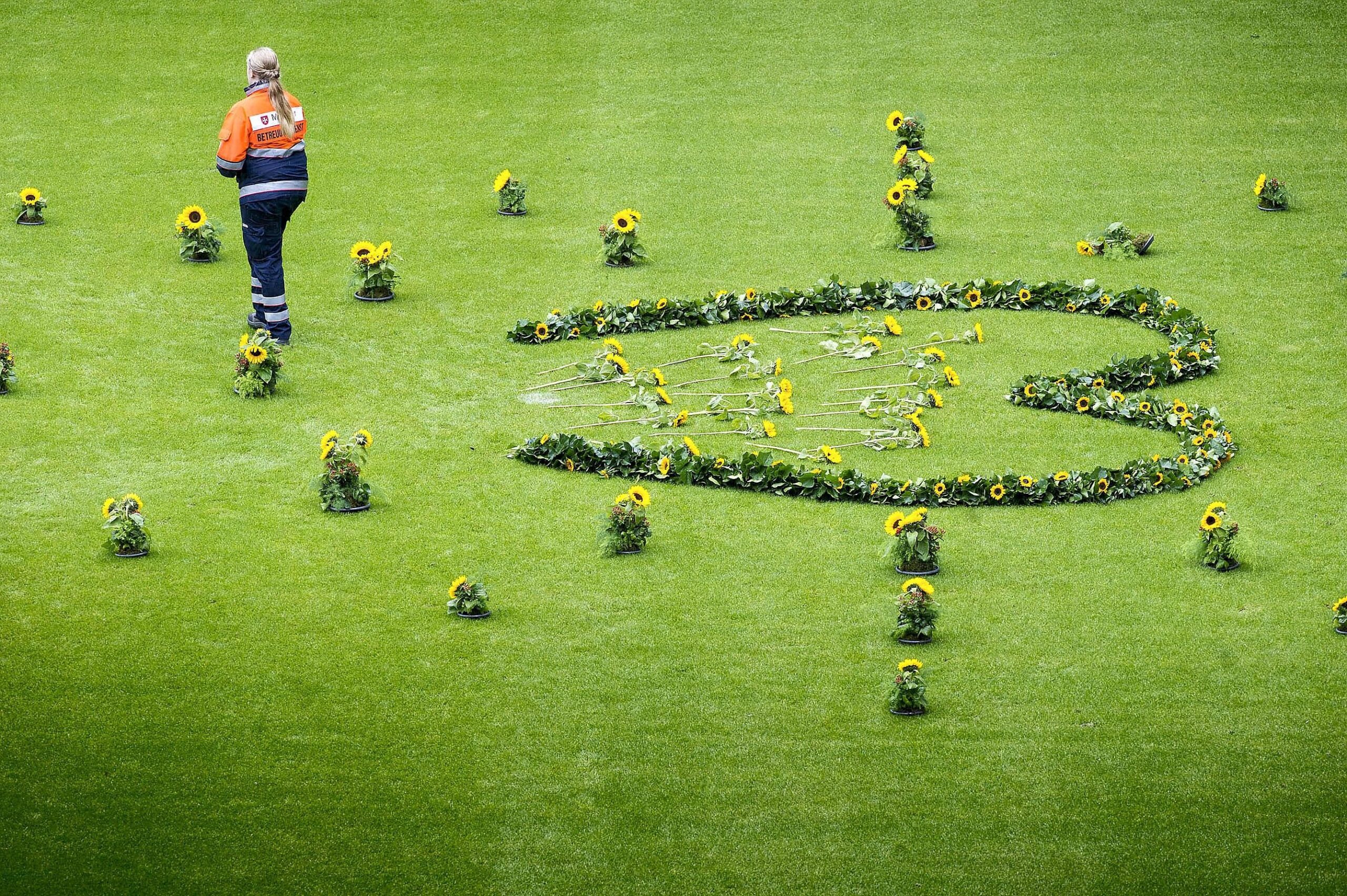 Helfer der Rettungsdienste legten in der MSV-Arena für jedes Todesopfer eine Sonneblume nieder.  Bild: Ilja Hoepping / WAZ FotoPool