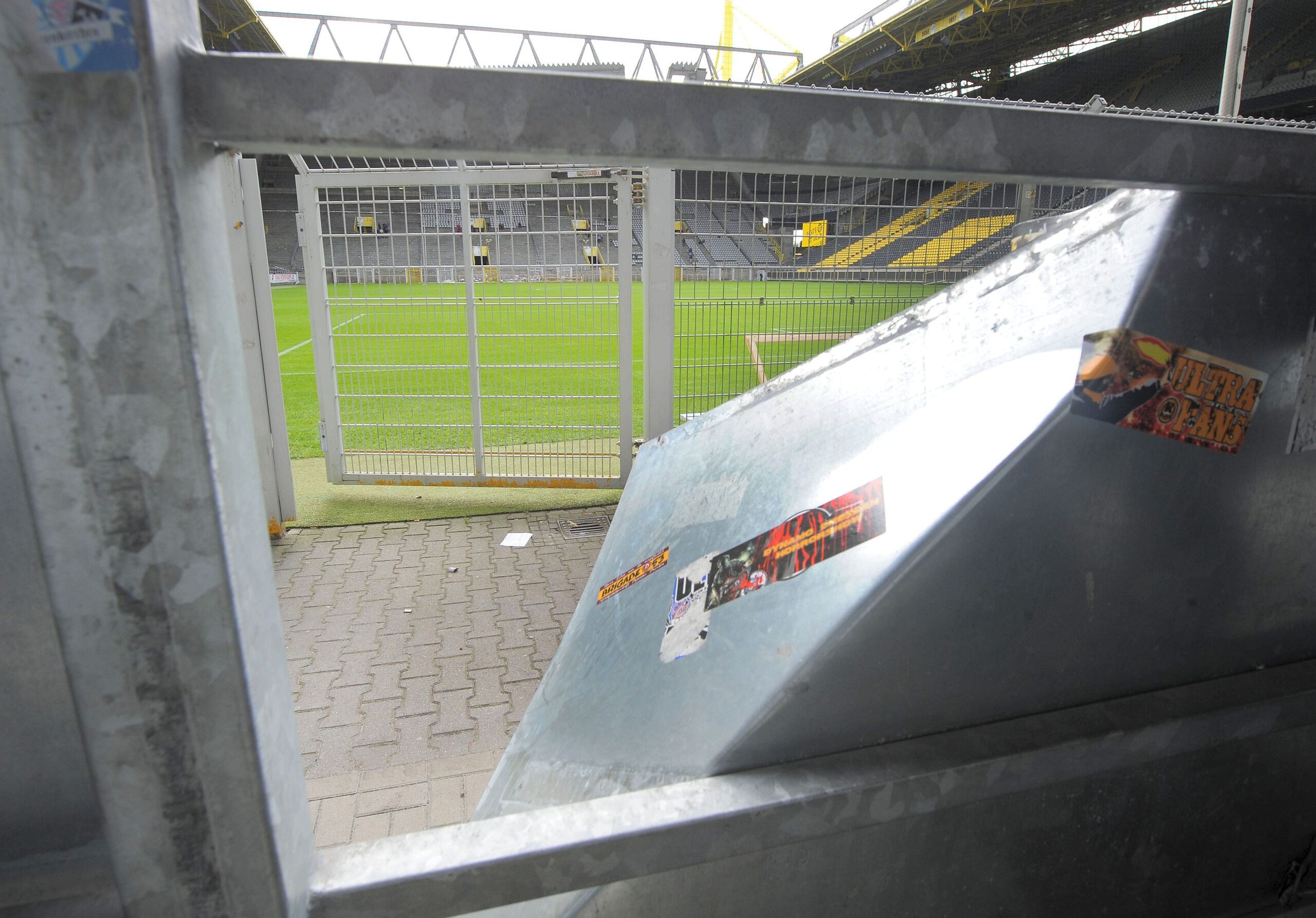 Am Tag nach dem Pokalspiel zwischen Borussia Dortmund und Dynamo Dresden zeigen sich die Schäden am Gästeblock: zerstörte Werbebanden, angekokelte Fahnen und Reste von Pyrotechnik..
