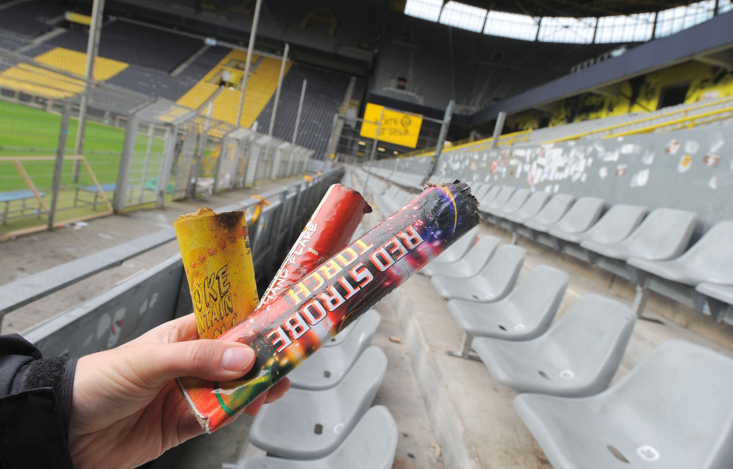 Am Tag nach dem Pokalspiel zwischen Borussia Dortmund und Dynamo Dresden zeigen sich die Schäden am Gästeblock: zerstörte Werbebanden, angekokelte Fahnen und Reste von Pyrotechnik.