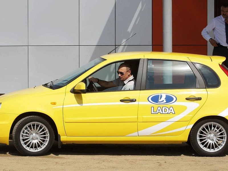Steuer, wie hier 2010, sieht man den Präsidenten öfter. Das gelbe Auto in dem er sitzt ist übrigens ein Lada Kalina - ein russisches Fabrikat. Gelbe Autos scheinen ihm zu gefallen, doch Putin...