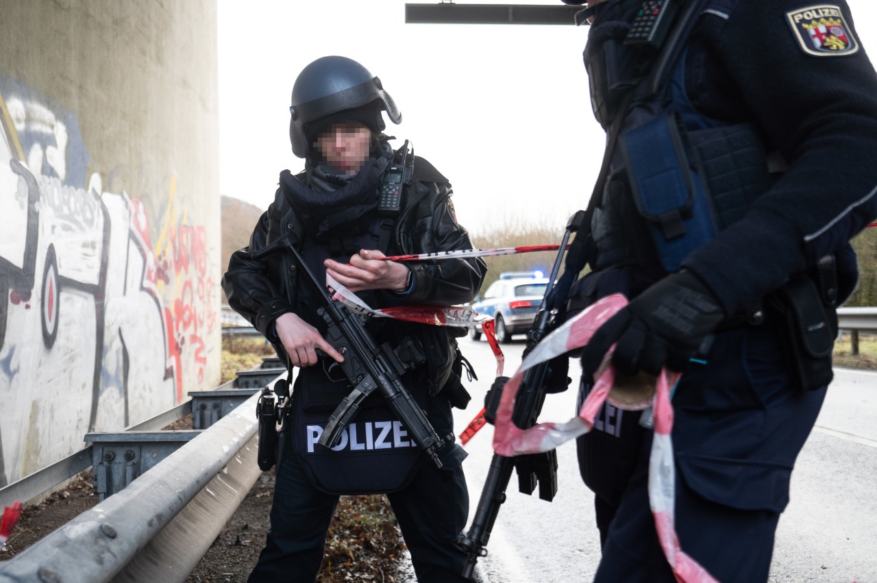 Archivfoto vom 31.01.2022, Rheinland-Pfalz, Mayweilerhof: Polizeibeamte sperren die Kreisstraße 22 rund einen Kilometer von dem Tatort entfernt, an dem zwei Polizeibeamte durch Schüsse getötet wurden. 