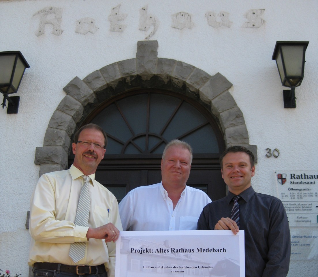 Bürgermeister Thomas Grosche (r.) mit  Architekt Peter Groß und Investor Michael Ricken (v.l.) vor dem Alten Rathaus mit einem Plan zum Umbau des Gebäudes. (Foto: WP Winterberg)