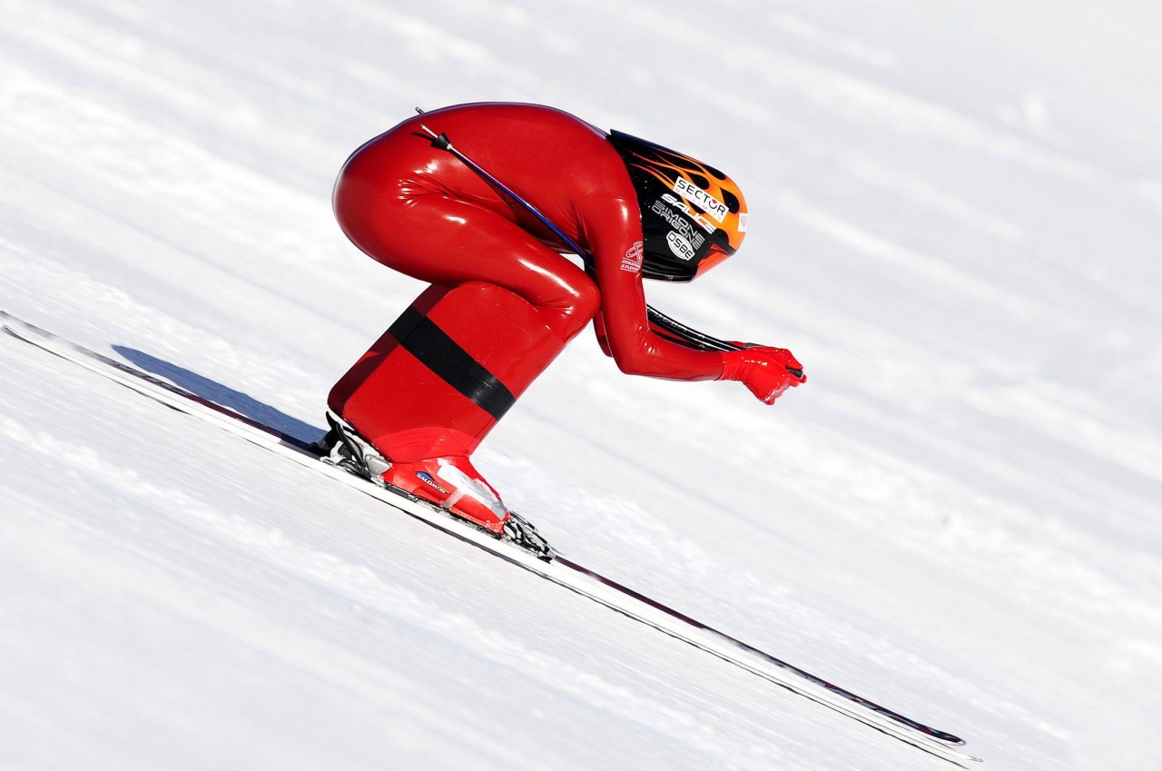 Beim Speedski trägt man einen enganliegenden glatten Rennanzug aus beschichtetem Polypropylen und einen aerodynamisch geformten Sporthelm.