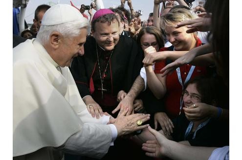 Papst Benedikt XVI. (l.) reicht Pilgern des Weltjugendtages die Hände. Der Besuch in Deutschland ist seine erste Auslandsreise.