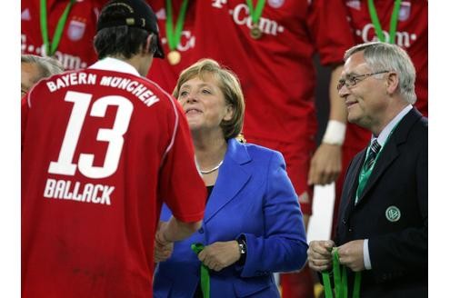 Ballack bei der Siegerehrung mit Bundeskanzlerin Merkel und DFB-Generalsekretär Schmidt ...
