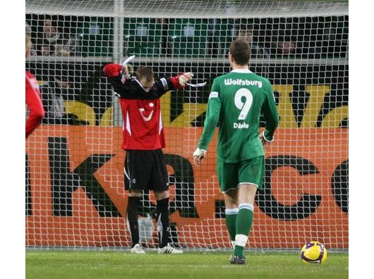 Hannovers Feldspieler Jan Rosenthal zieht sich das Torwart-Trikot an während Dzeko zum Elfmeter antritt - Rosenthal hält. Foto: imago