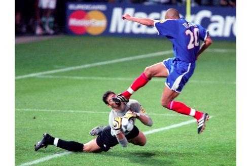 Francesco Toldo hat den Ball zwar längst sicher. Das hindert David Trezeguet aber nicht daran, im Endspiel der EM 2000 voll durchzuziehen.