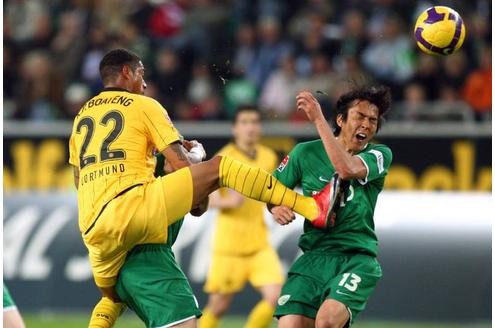 Der Dortmunder Kevin Prince Boateng springt mit gestrecktem Bein in Wolfsburgs foult Makoto Hasebe hinein.