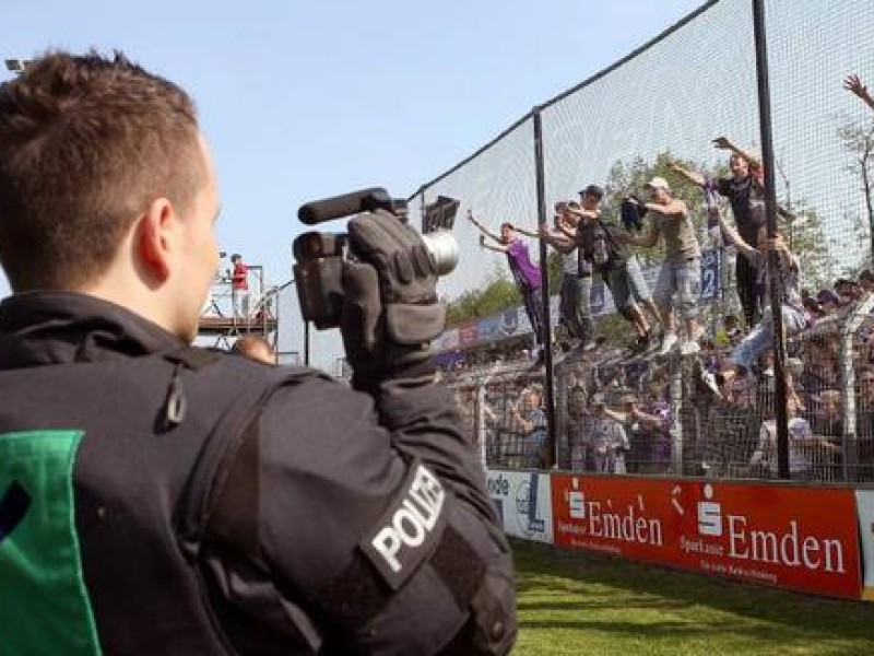Ein Polizist nimmt mit einer Kamera Osnabrücker Fans ins Visier.