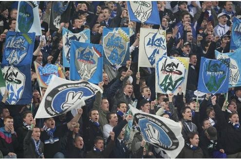 Schalker Fans und Ultras mit Fahnen und Doppelhaltern.