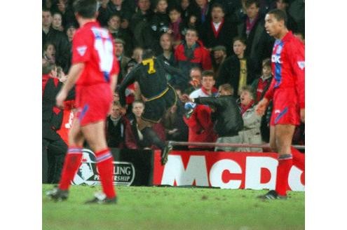 ...Eric Cantona (Manchester United) springt mit einem Karatetritt in die Zuschauerränge...