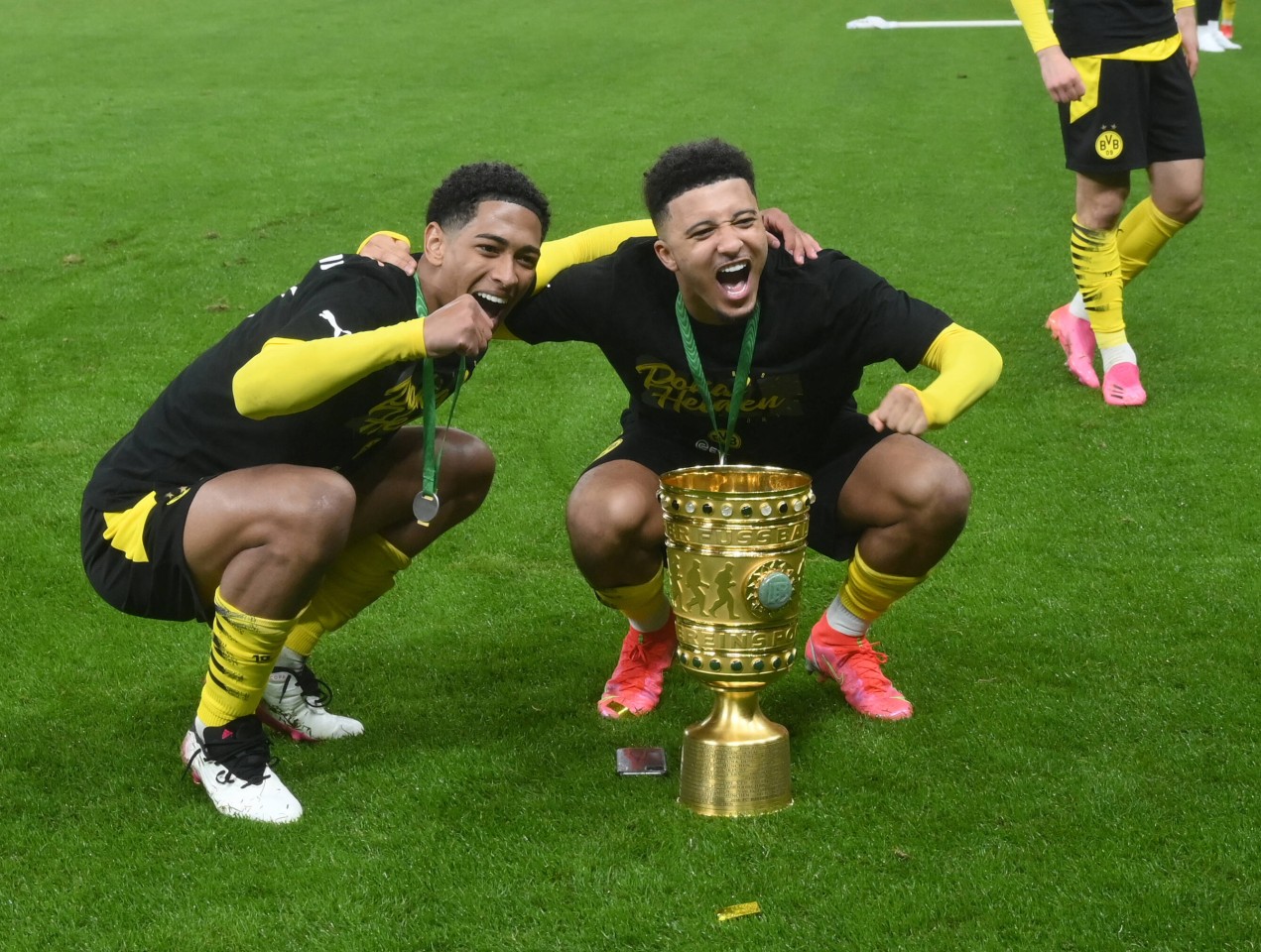 Borussia Dortmund: Jude Bellingham (l.) posiert mit Jadon Sancho und dem Pokal.