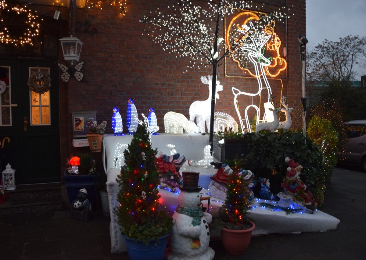 Hier sieht es richtig weihnachtlich aus., Figuren schmücken den Eingang der Krauses., An der Hauswand leuchten Bilder., Das Haus leuchtet von ganz oben bis unten.