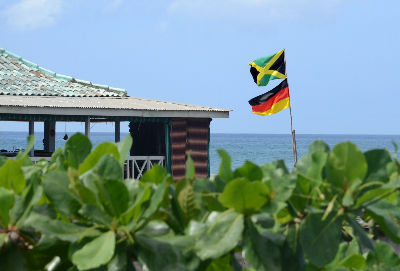 Eine deutsche und eine jamaikanische Fahne wehen am 24.10.2017 an dem von einem Ehepaar aus Thüringen im jamaikanischen Küstenort Negril gegründeten Restaurant "German Bar".  (zu dpa "Thüringen in Jamaika" am 12.11.2017) Foto: Georg Ismar/dpa +++(c) dpa - Bildfunk+++  