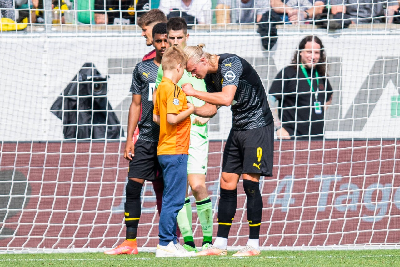 Erling Haaland unterschreibt dem keinen Fan sein Trikot.