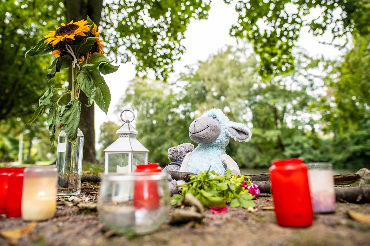 Hamm: Am Tag nach dem Fund der Frauenleiche sind Blumen, Kerzen und ein Stofftier im Park nahe des Oberlandesgerichts abgelegt.
