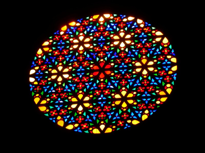 Farbspiele: Über dem Altar und auf der gegenüberliegenden Westseite der Kathedrale von Palma ist jeweils ein riesiges Rosettenfenster in die Wand eingelassen. 

