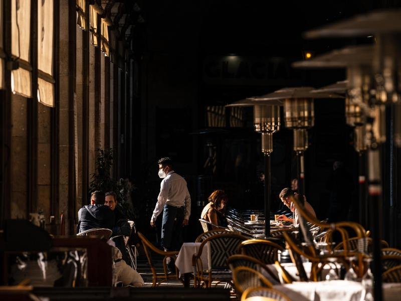Menschen sitzen in einem wiedereröffneten Restaurant in Barcelona. Die Lage im Corona-Hochinzidenzgebiet Spanien bessert sich.