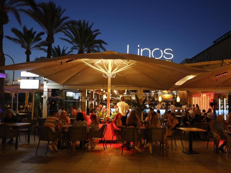 Menschen sitzen in einer Bar an der Strandpromenade von Palma. Angesichts fallender Corona-Zahlen dürfen ab dem 07.09. wieder Personen aus verschiedenen Haushalten zu nächtlichen Partys zusammenkommen.