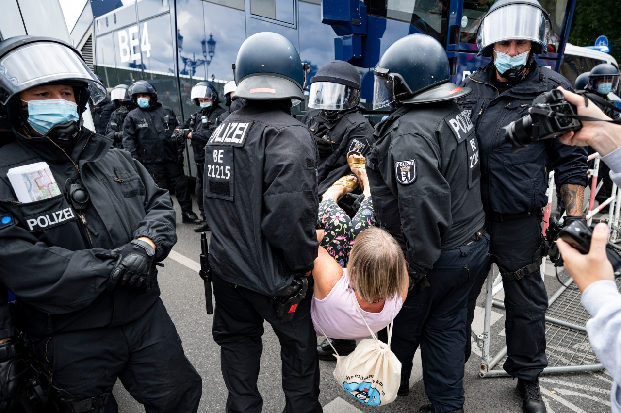 Die Polizei trägt bei der Querdenker-Demo in Berlin eine Demonstrantin weg. Obwohl es verboten war, demonstrierten Tausende.