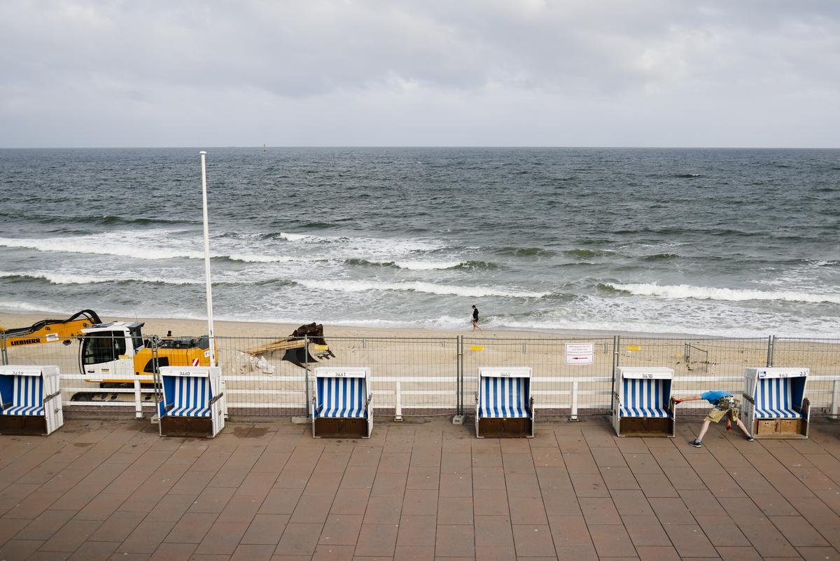 Strandkorbwärter Mathias Tognino (r) richtet einen Strandkorb aus auf der Promenade von Westerland auf Sylt.
